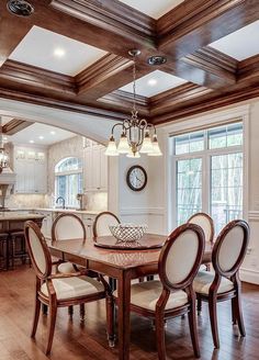 a dining room table with chairs and a clock on the wall