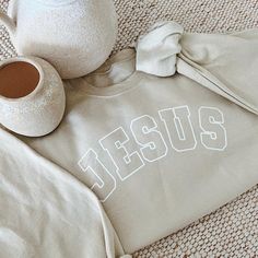 "Jesus" beige sweatshirt. This beautifully designed sweatshirt is a comfortable and stylish way to express your faith and gratitude. * 100% ring-spun cotton * Soft ring spun cotton fabric with 100% cotton threads * True to size unisex fit   Share your faith and stay warm in style with our "Jesus" Christian sweatshirt. Order yours today and make a powerful statement of faith wherever you go.   Care Instructions: - Wash inside out with cold water - Do not bleach - Do not Iron on the logo - Low setting for tumble dry  *ALL SALES ARE FINAL Cream Letter Print Sweatshirt For Loungewear, Relaxed Fit Cream Sweater With Letter Print, Beige Relaxed Fit Sweater With Letter Print, Beige Cotton Sweatshirt With Letter Print, Beige Letter Print Sweatshirt For Loungewear, Beige Cotton Sweater With Letter Print, Beige Letter Print Sweatshirt For Fall, Beige Long Sleeve T-shirt With Letter Print, Statement Of Faith