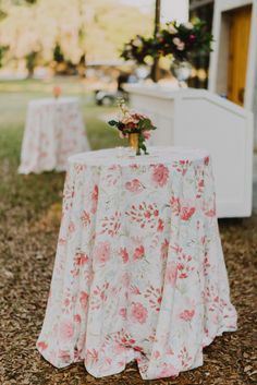 a table with flowers on it sitting in the grass