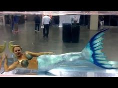 a woman in a mermaid costume is floating on the water with her legs spread out