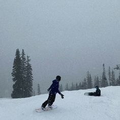 two snowboarders are going down a snowy hill