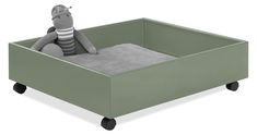 a gray stuffed animal sitting in a green toy box with wheels on the bottom and sides