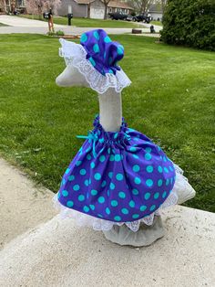 a duck wearing a blue and white polka dot dress