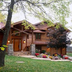 a large house with lots of trees and flowers in the front yard