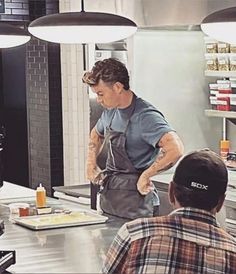 a man standing in front of a counter preparing food