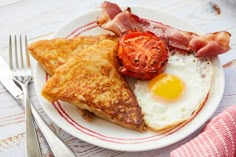 a white plate topped with eggs, bacon and toast