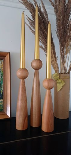 three wooden candlesticks sitting on top of a table