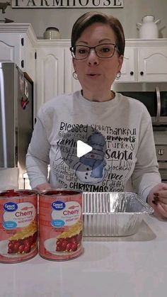 a woman standing in front of two cans of food