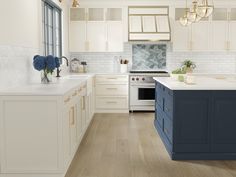 a kitchen with white cabinets and blue counter tops, along with an island in the middle