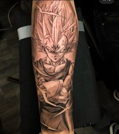 a man's arm with a dragon tattoo on it and the image of gohan