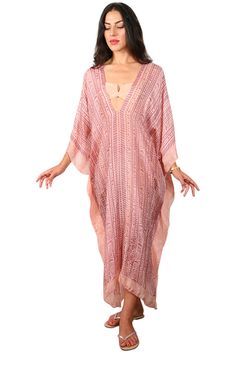 Our "3/4 Long V-Neck Kaftan" in our beautiful Silk Tabi quality is an easy but elegant kaftan to throw on and go. Great over swimwear or worn over a slip dress. The kaftan is a One Size fits all and can accommodate XS-2XL. Fabrication Content: 100% Silk Print Process: 100% hand block IKAT print, and every item is made by hand and a one of a kind item & limited items will be made in this style, Soft pink base with soft plum print. Size run: One Size Made in: Garment is custom made in LA - allow for 3 days in making plus transit time Care: Dry Clean Or rinse by hand in Luke warm water with small amount of detergent in the sink. The fabric is delicate so rise only, no rubbing. Hang on a hanger to dry and the item dries in 2 minutes. To see all the options filter : Beachwear" >>> "Kaftans" to Elegant V-neck Kaftan For Vacation, V-neck Kaftan For Resort Season, Spring Vacation V-neck Poncho, Flowy V-neck Tunic For Beach Cover-up, Spring V-neck Kaftan For Beachwear, Spring V-neck Beachwear Kaftan, Elegant Free Size Kaftan For Beach, Elegant Free Size Beach Kaftan, Elegant Free-size Kaftan For The Beach