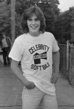 an old photo of a young man standing in front of a tennis ball racket