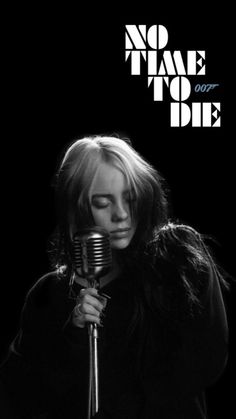 a woman holding a microphone with the words no time to die on it