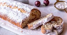 there is a loaf of bread with powdered sugar on the top and one slice cut off