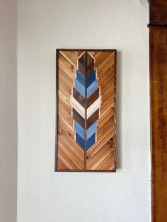 a painting hanging on the wall next to a wooden frame with an arrow painted on it