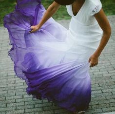 a woman in a purple dress is walking down the street