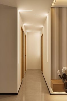 an empty hallway is lit by recessed lighting and wooden slats on the walls