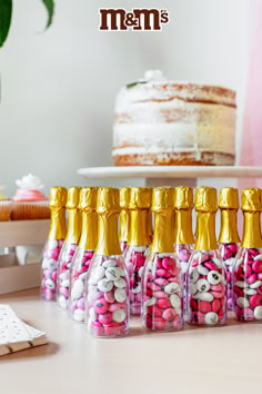 bottles filled with candy sitting on top of a table next to a cake and cupcake