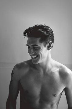 black and white photograph of a shirtless man smiling