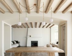 a large wooden table sitting in the middle of a living room next to a fire place