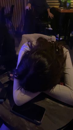 a woman laying on top of a pillow with her head resting on a laptop computer