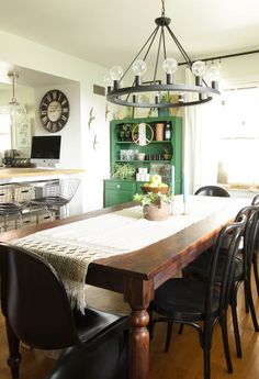 the dining room table is set with black chairs