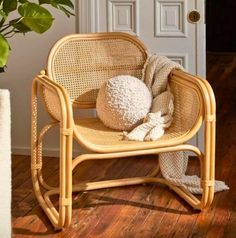 a chair with a stuffed animal on it in front of a door and potted plant