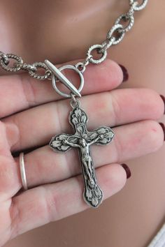 This is a stunning thick antique chain choker necklace with a very large crucifix cross pendant! This amazingly detailed crucifix hangs from front toggle.  Edgy yet symbolic your going to love the look of this statement piece!  Perfect for men or women this will surely make a statement!  Pendant is pewter, measures 50x30mm.  Chain is antique steel etched links measure 11x9, 2mm thick.   Toggle is pewter 22mm bar, 15mm diameter.  Model is wearing a 16" length.  Comes in a gift box, ready to prese Catholic Jewelry Necklace, Crucifix Necklace, Catholic Jewelry, Chain Choker Necklace, Statement Pendant, Necklace Women, Choker Necklaces, Cross Pendant Necklace, Chain Choker