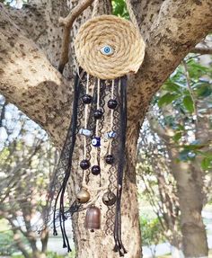 a tree with an evil eye hanging from it's branches and beads around the eyes