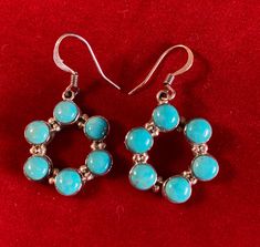 These Turquoise earrings are simple yet sophisticated at the same time. Pretty turquoise blue and shiny sterling silver makes up each circle. Measures 1 1/2 inches from the top of the hook to the bottom of the circle and a width of 6/8".  Native American handcrafted. These are bold, bright, and beautiful. Hypoallergenic Blue Circular Jewelry, Turquoise Round Pierced Jewelry, Nickel-free Turquoise Circle Jewelry, Turquoise Round Sterling Silver Earrings, Turquoise Circle Earrings Gift, Turquoise Sterling Silver Round Hoop Earrings, Turquoise Hypoallergenic Round Hoop Earrings, Turquoise Hypoallergenic Hoop Earrings, Hypoallergenic Turquoise Round Hoop Earrings