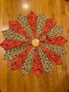 a large red and green flower sitting on top of a wooden floor