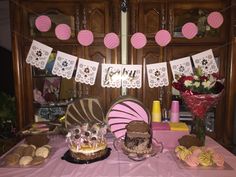 a pink table topped with cakes and desserts