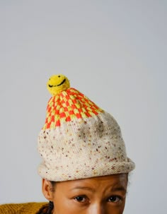 a woman wearing a knitted hat with a smiley face