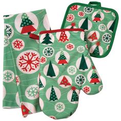 two oven mitts are decorated with christmas trees and snowflakes on green fabric