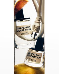 a glass tube with some oranges and toothbrushes in it next to a bottle of grapefruit generation