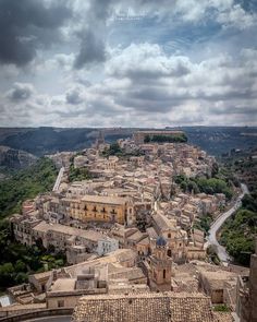 an aerial view of a city with old buildings and cobblestone streets, under a cloudy sky