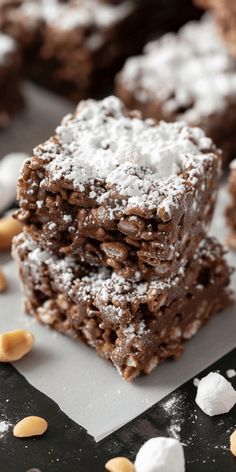 some brownies are stacked on top of each other and covered in powdered sugar