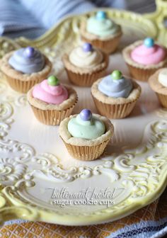 small cupcakes with frosting and sprinkles sitting on a plate