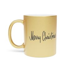 a gold coffee mug with merry christmas written on the side and black writing across it