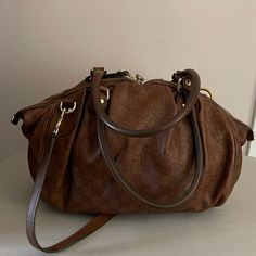 Medium Sized Brown Leather Gucci Bag. It Is Versatile Bag That Can Be Used For Work Or A Casual Night Out. It Has A Zip Closure And One Pocket On The Inside. The Shoulder Straps Are Adjustable. This Bag Had Minimal Use And Was Well Taken Care Of. Chic Gucci Satchel With Removable Pouch, Everyday Handheld Gucci Satchel, Gucci Satchel With Detachable Strap For Shopping, Gucci Shoulder Bag With Detachable Strap In Monogram Canvas, Gucci Monogram Canvas Shoulder Bag With Detachable Strap, Chic Gucci Bag With Double Handle, Chic Gucci Double Handle Bags, Gucci Handheld Shoulder Bag For Everyday Use, Gucci Handheld Bag With Detachable Handle