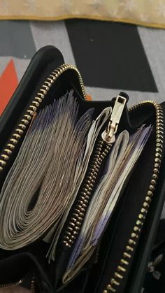 an open black purse with multiple zippers