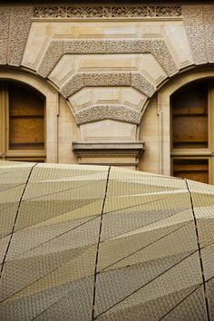 an umbrella is sitting on the ground in front of a building that has stone arches and arched doorways