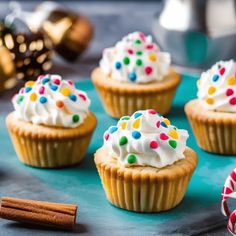 small cupcakes with white frosting and sprinkles on a tray