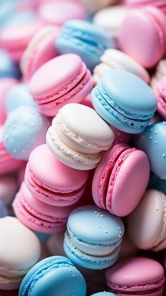 many different colored macaroons are on display in this photo, including blue and pink