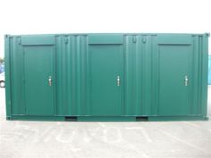 several green portable toilets in a parking lot