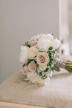 a bridal bouquet sitting on top of a wooden bench in front of a mirror