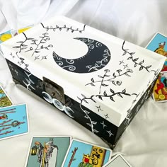 a box that has some cards in it on a bed with other items around it