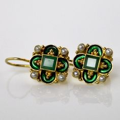 This unique Arts & Crafts Movement design showcases an onyx, iolite, blue topaz, emerald, or garnet set in a cloverleaf of emerald-green or royal blue enamel work, accented with cultured pearl. 24k gold over sterling silver. European back for pierced ears. Size: 3/4 inch. Elegant Enamel Dangle Jewelry, Elegant Pierced Enamel Jewelry, Elegant Gemstone Earrings With Enamel, Elegant Enamel Earrings With Gemstones, Green Enamel Jewelry With Gemstones, Victorian Jeweled Earrings Gift, Jeweled Enamel Earrings For Gift, Byzantine Gemstone Jewelry For Gift, Elegant Enamel Jewelry With Gemstone