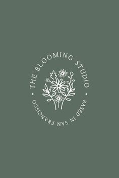 the blooming studio logo on a dark green background with white flowers and leaves in the center