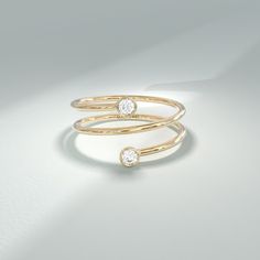 a gold ring with two diamonds on the top and one diamond in the middle, against a white background